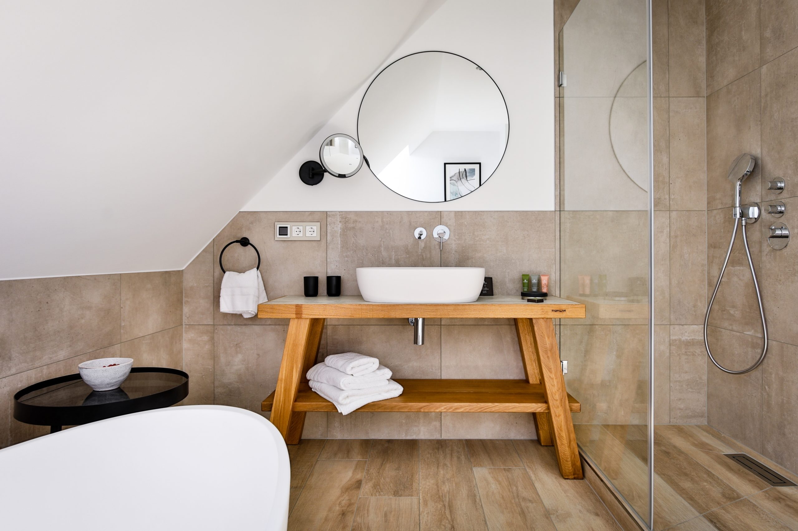 Das Bild zeigt ein modernes Badezimmer mit Dusche und Badewanne im Hotel Landhaus Sylter Hahn in Westerland auf Sylt.