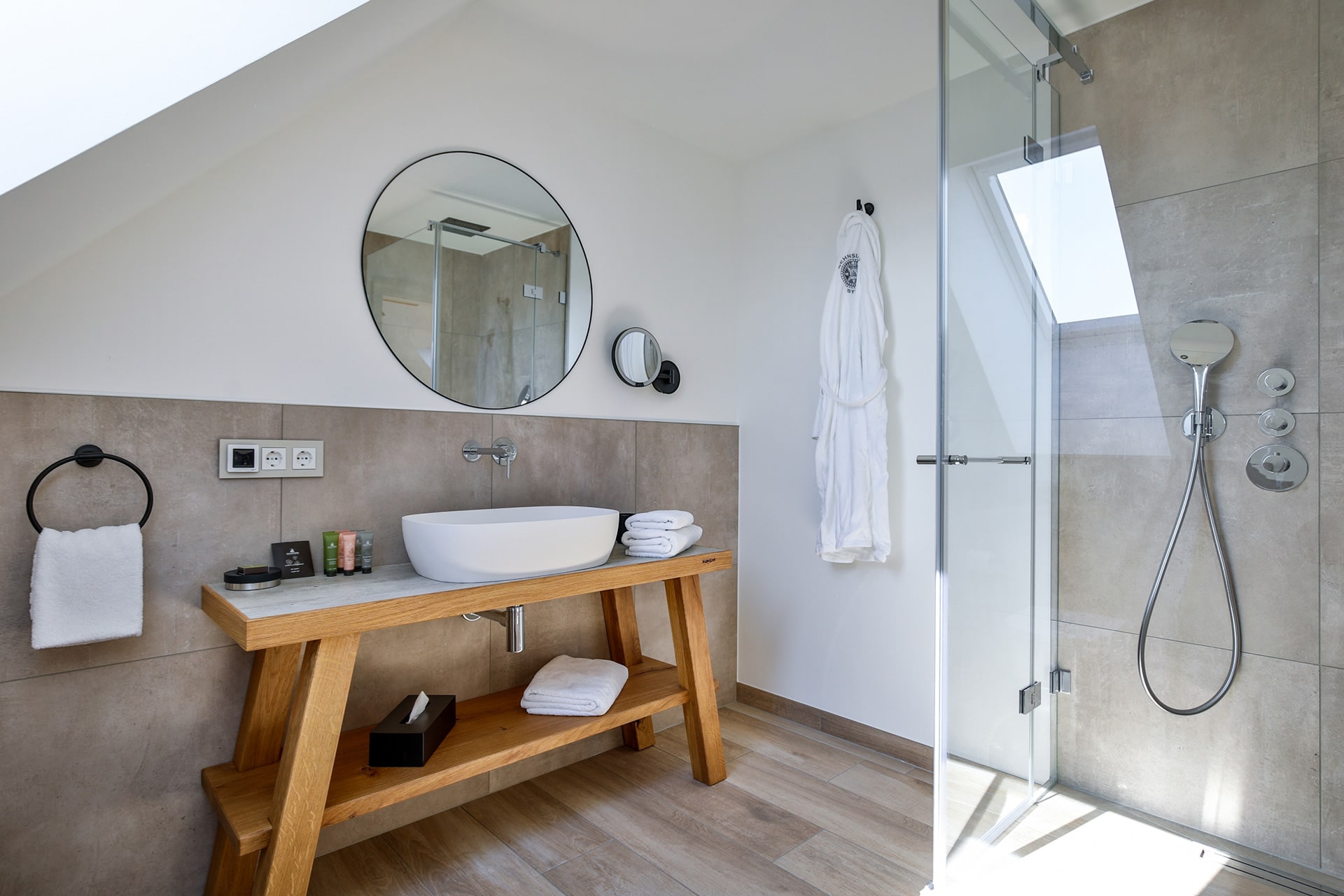 Das Bild zeigt ein modernes Badezimmer mit Dusche im Hotel Landhaus Sylter Hahn in Westerland auf Sylt.