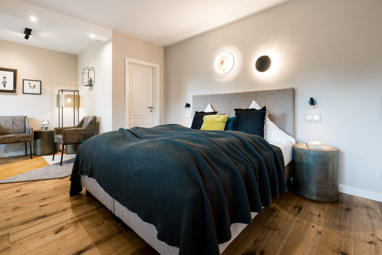 Doppelzimmer mit großem Doppelbett mit Tagesdecke und zwei Nachttischen im Hotel Landhaus Sylter Hahn in Westerland auf Sylt.