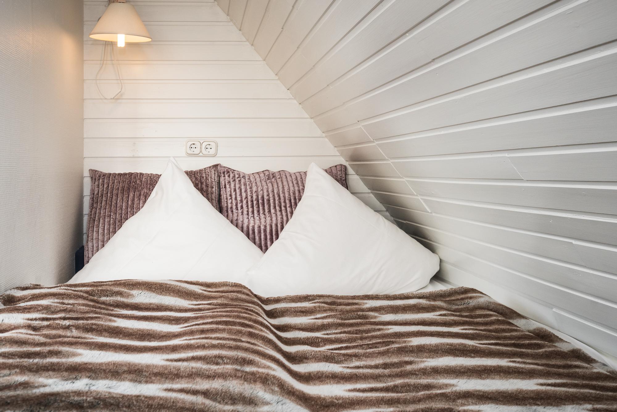 Gemütliches Doppelbett im Hotel Landhaus Sylter Hahn in Westerland auf Sylt.