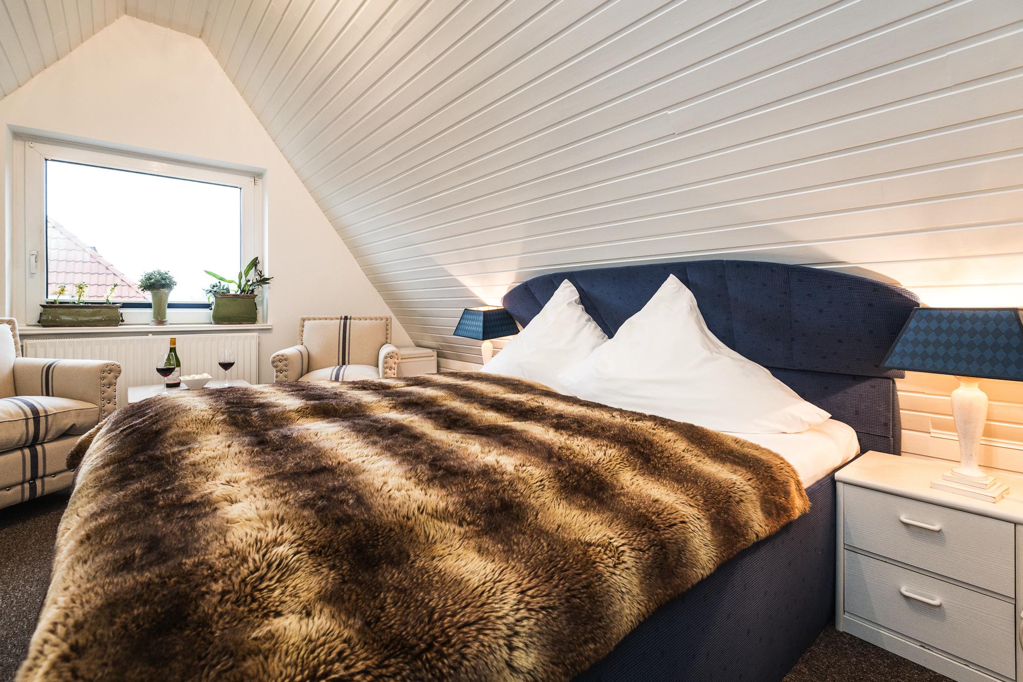 Gemütliches Wohn- Schlafzimmer mit Doppelbett im Hotel Landhaus Sylter Hahn in Westerland.